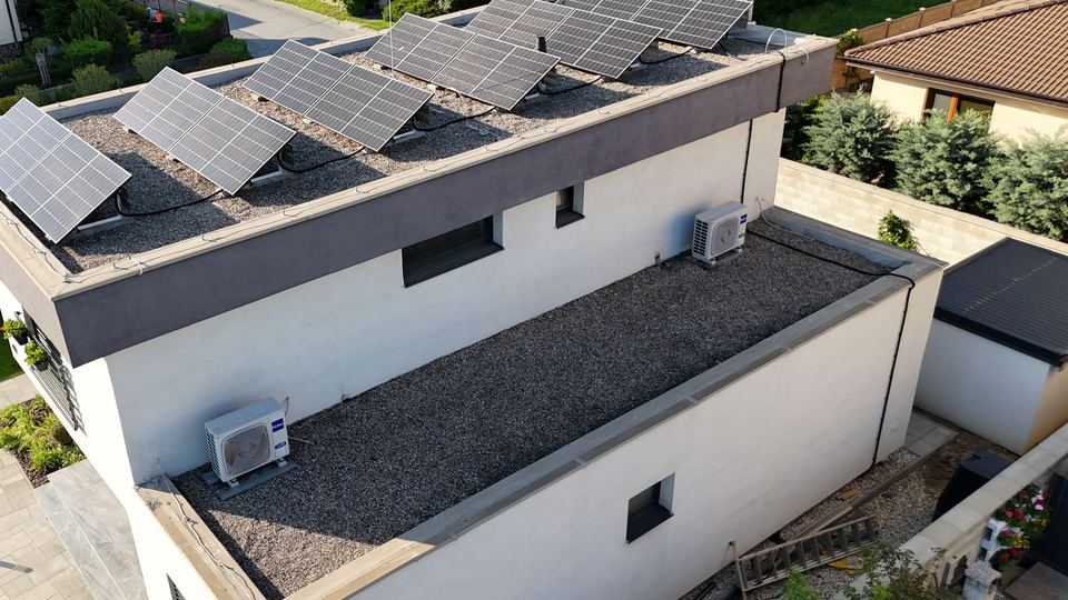 Rovná strecha rodinného domu s panelmi na sklopených rámoch